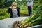 Toddler boy looking at harvested fully grown onions. Growing own vegetables in a homestead. Gardening and lifestyle of self-