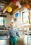 A toddler boy with a party hat walking inside at home.