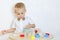 A toddler boy playing with kinetic sand, a great activity to develop fine motor skills