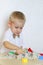 A toddler boy playing with kinetic sand, a great activity to develop fine motor skills