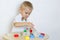 A toddler boy playing with kinetic sand, a great activity to develop fine motor skills