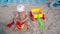 Toddler boy playing with sand and toys on beach. Family vacation concept