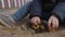 Toddler boy playing with toy car in sandbox.