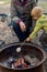 Toddler boy roasting large marshmallow on a stick over the campfire firepit. Camping family fun