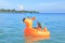 Toddler boy sailing inflating ring on sea