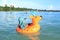 Toddler boy sailing inflating ring on sea