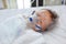 Toddler boy using nebulizer to cure asthma or pneumonia disease . Sick baby boy rest on patients bed and has inhalation therapy by