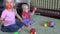 Toddler brother and 4 years old sister playing with colorful balls at home.