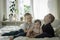 toddler brothers and sister sitting on bed together. Lifestyle family concept