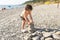 Toddler building pebbles tower on the beach