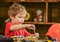 Toddler on busy face plays with bolts at home in workshop. Kid boy play as handyman. Child cute and adorable playing