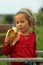 Toddler caucasian girl enjoying eating  banana outdoor