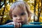 Toddler child little girl sad in the park against the background of autumn foliage. Summer is over. Portrait of a pensive sad girl