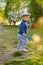 Toddler child outdoors. Rural scene with one year old baby boy wearing flat cap