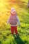 Toddler child in warm vest jacket outdoors. Baby boy at park during sunset.