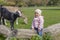 Toddler climbing with a young black goad on a dried out tree