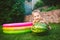 Toddler cute Caucasian white European race boy sitting hugging holding huge watermelon and smiling on background of green grass,