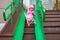 Toddler drags a toy stroller along the ramp of the stairs