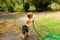 A toddler drinking water from a hose