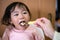 A toddler eating natto - a Japanese fermented soy beans. Healthy food. Hand feeding