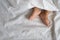 Toddler feet in white bed,sheet and pillow