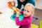 Toddler girl in child occupational therapy session doing sensory playful exercises with her therapist.