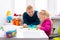 Toddler girl in child occupational therapy session doing sensory playful exercises with her therapist.