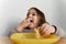 Toddler girl eating bread or pie at home with her hands. Hungry kid. Unhealthy diet. Bad table manners