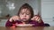 Toddler girl eats spaghetti with tomatoes and cream at home with hands. messy baby mealtime
