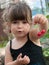 Toddler girl hanging pair of cherries on her ear
