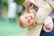 Toddler girl having fun on outdoor playground. Merry young mother swinging her little daughter. Spring/summer/autumn active