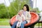 Toddler girl having fun on outdoor playground. Young mother rides daughter on swing. Spring/summer/autumn active leisure for