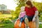 Toddler girl and her dad sitting on huge pumpkins on a pumpkin patch. Kids picking pumpkins at country farm on warm autumn day