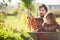 Toddler girl and her father harvesting carrot at the wheelbarrow.