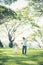 Toddler girl holding hands with her father in the park