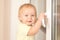 Toddler girl holding window knob
