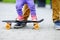 Toddler girl learning to skateboard with her father close up