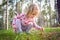 toddler girl picking mushrooms in a forest.