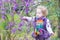 Toddler girl picking purple berries in autumn park