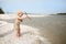 Toddler Girl Playing on Beach Throwing Sticks in the Water