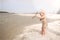 Toddler Girl Playing on Beach Throwing Sticks in the Water