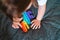 Toddler girl with popit toy in rainbow colours. Dino shape silicone toy for stress relief. Bubbles sensory trendy fidget