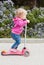 Toddler girl on a scooter in a park