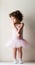 Toddler girl standing in pink tutu