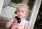 Toddler girl talking by the city phone