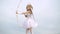Toddler girl wearing angel costume white dress and feather wings. Angel child girl with curly blonde hair. Little angel