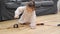 Toddler girl in white dress plays with wooden train at home in the living room. Independent play concept