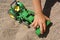 Toddler hand pushing toy truck in the sand