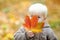 Toddler having fun in autumn, focus on leaf