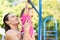 Toddler having a great time hanging on the monkey bars with her uncle getting a workout.